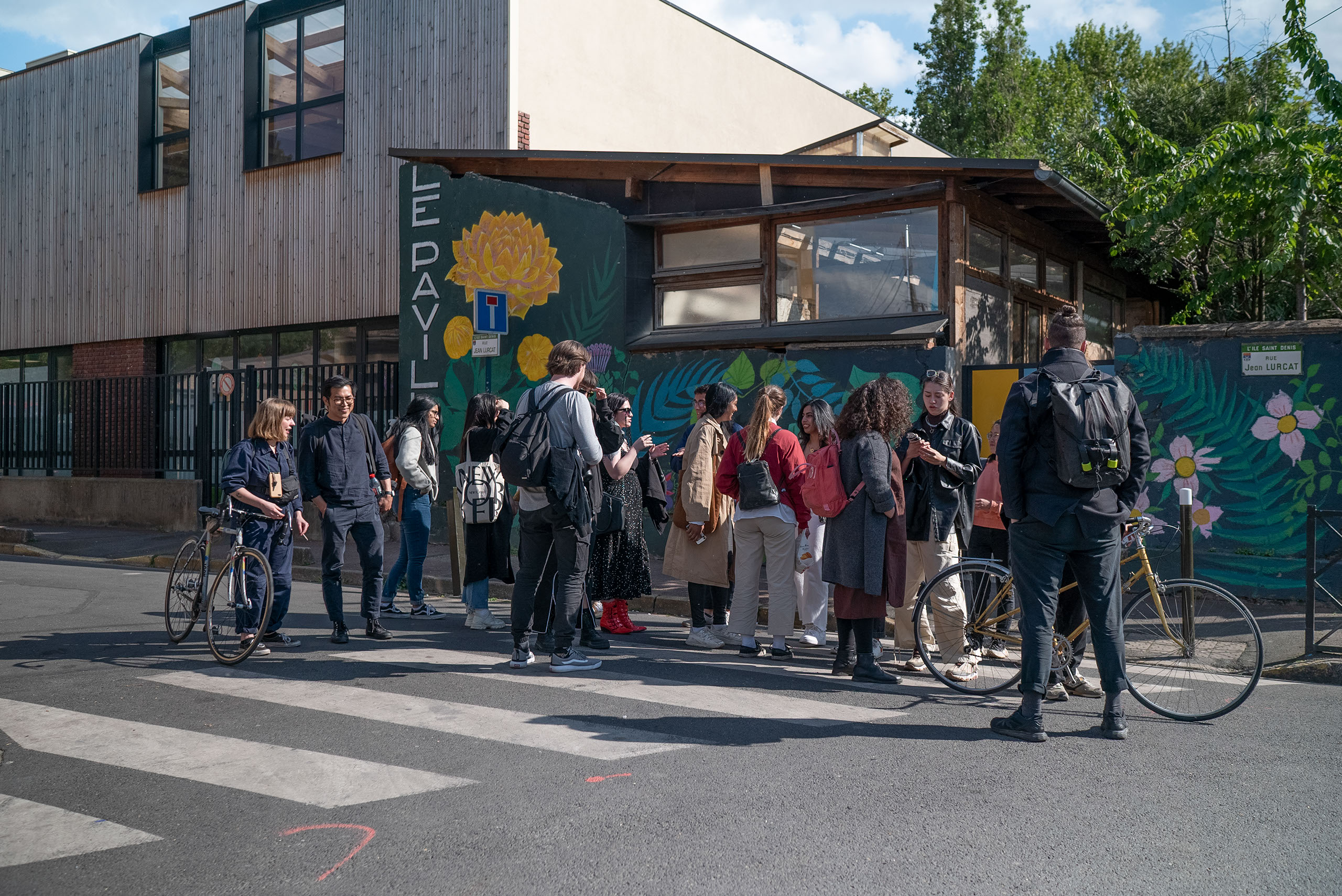 Students stand at a bus stop