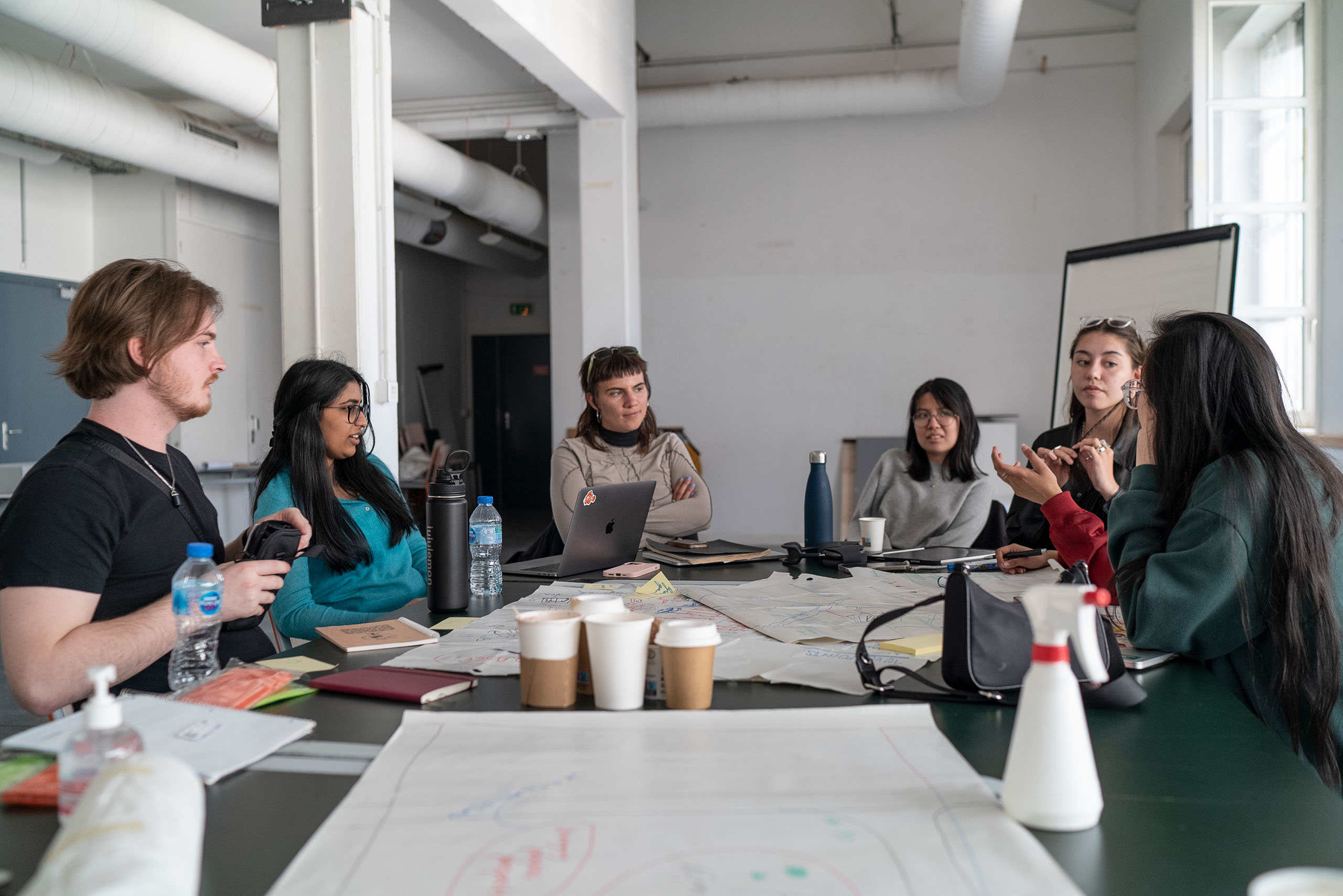 Student discussing while sitting around a table in a meeting room