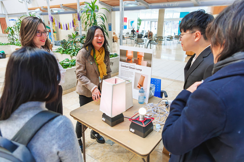 Ranee Lee and students examine a product. 