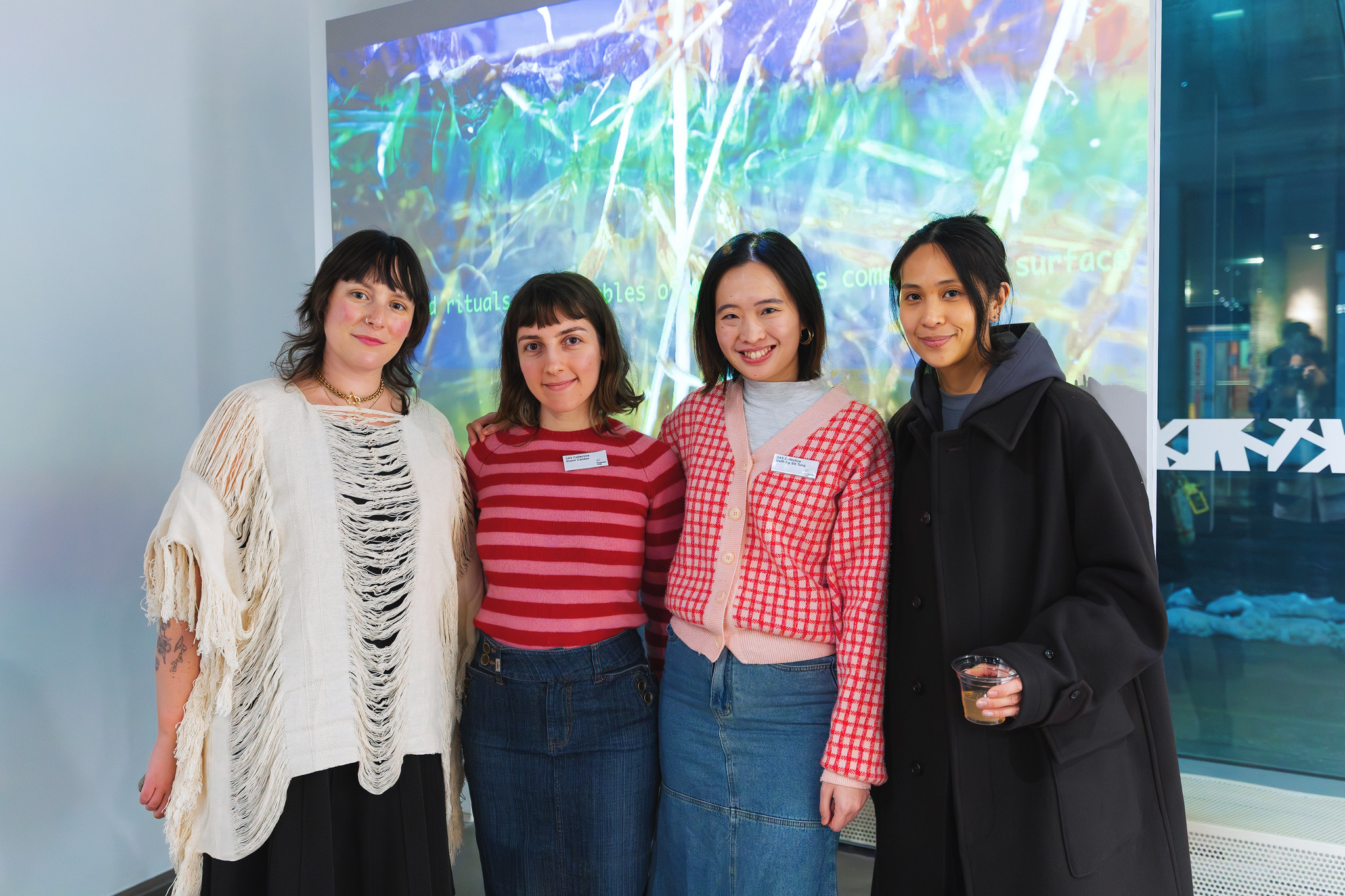 The artists and curators of Metabolic Loop stand in front of an artwork