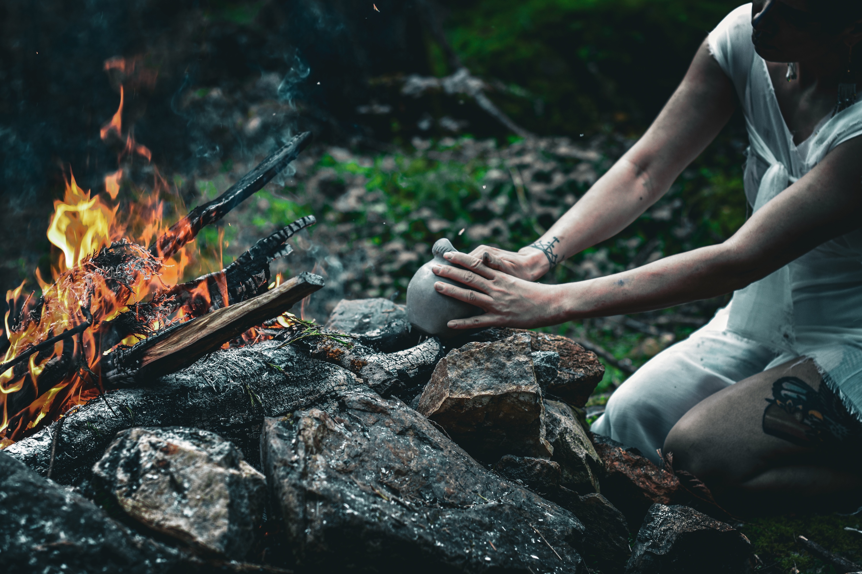 A person sitting near a fire pit