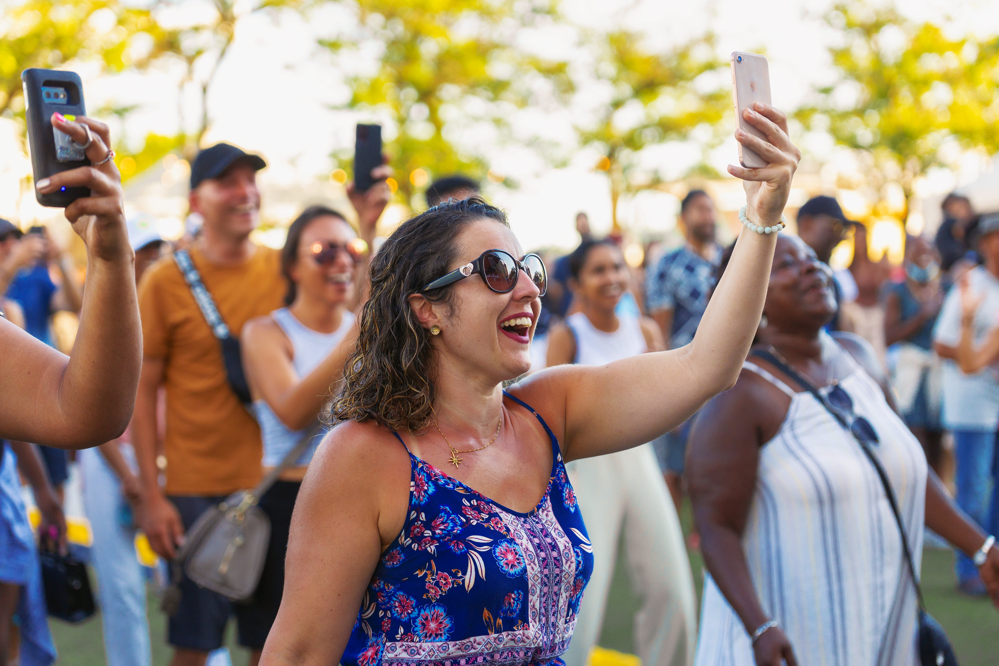 Group of people holding up phones to take photos