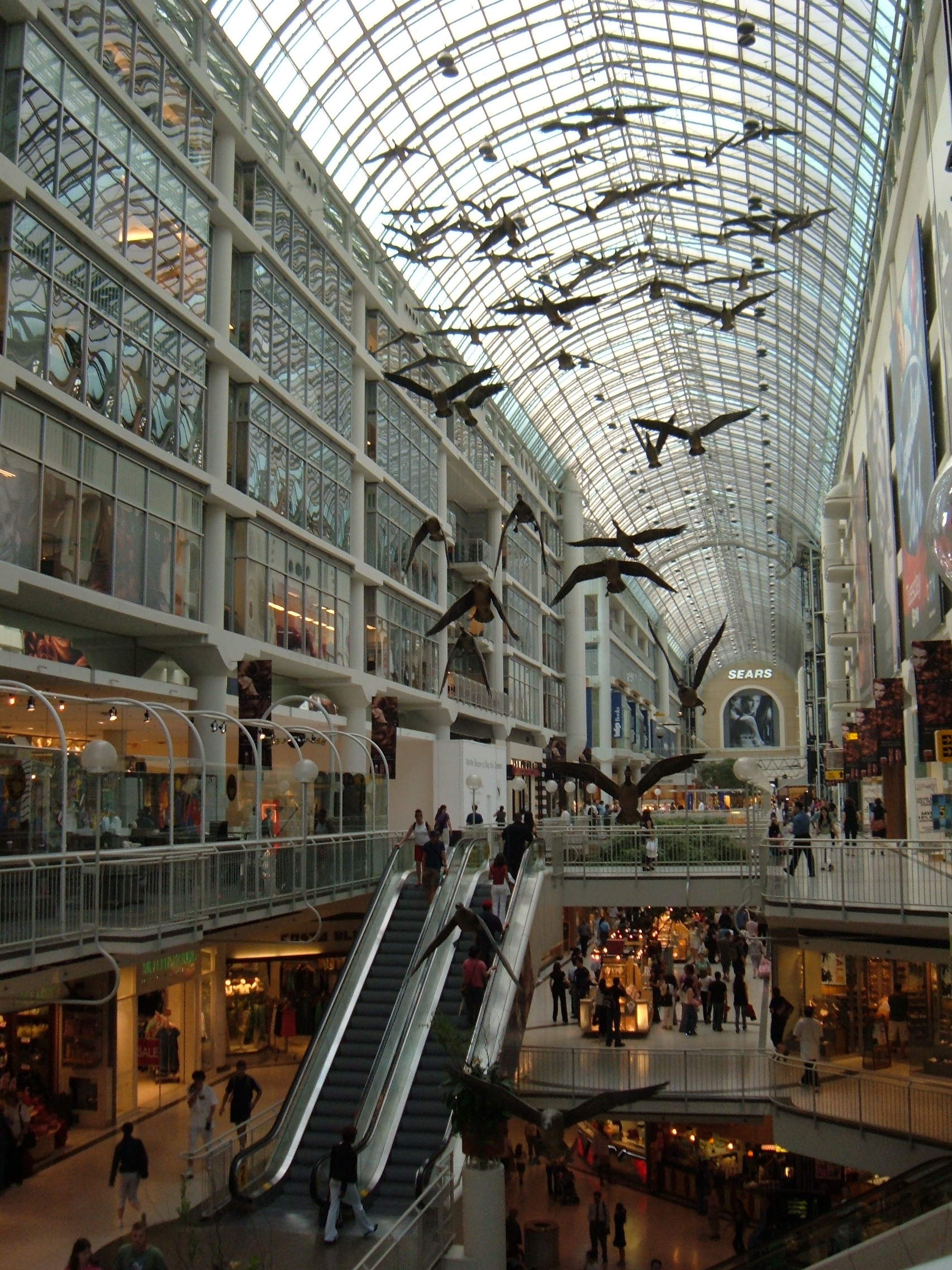 Michael Snow, Flight Stop, 1979  60 suspended fibreglass Canada goose forms surfaced with tinted black and white photographs, 32 x 20 x 16 m  Toronto Eaton Centre