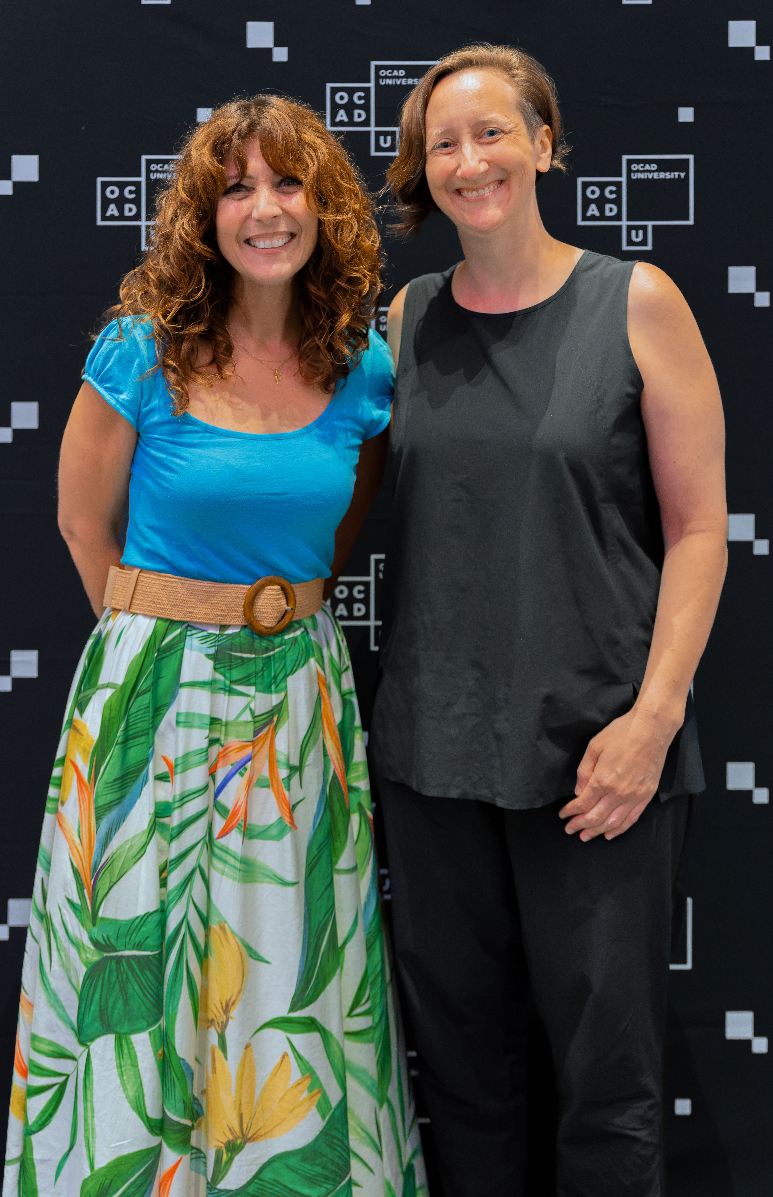 Left to right: Dr. Gabriele wearing a blue top and green and white skirt with Kate Hartman wearing black top and black pants. 