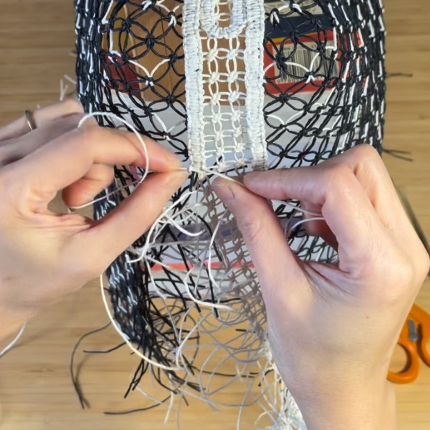 Person stitching together intricated knotted sculptures