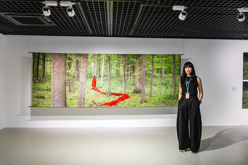 Artist Melissa General standing in front of her artwork