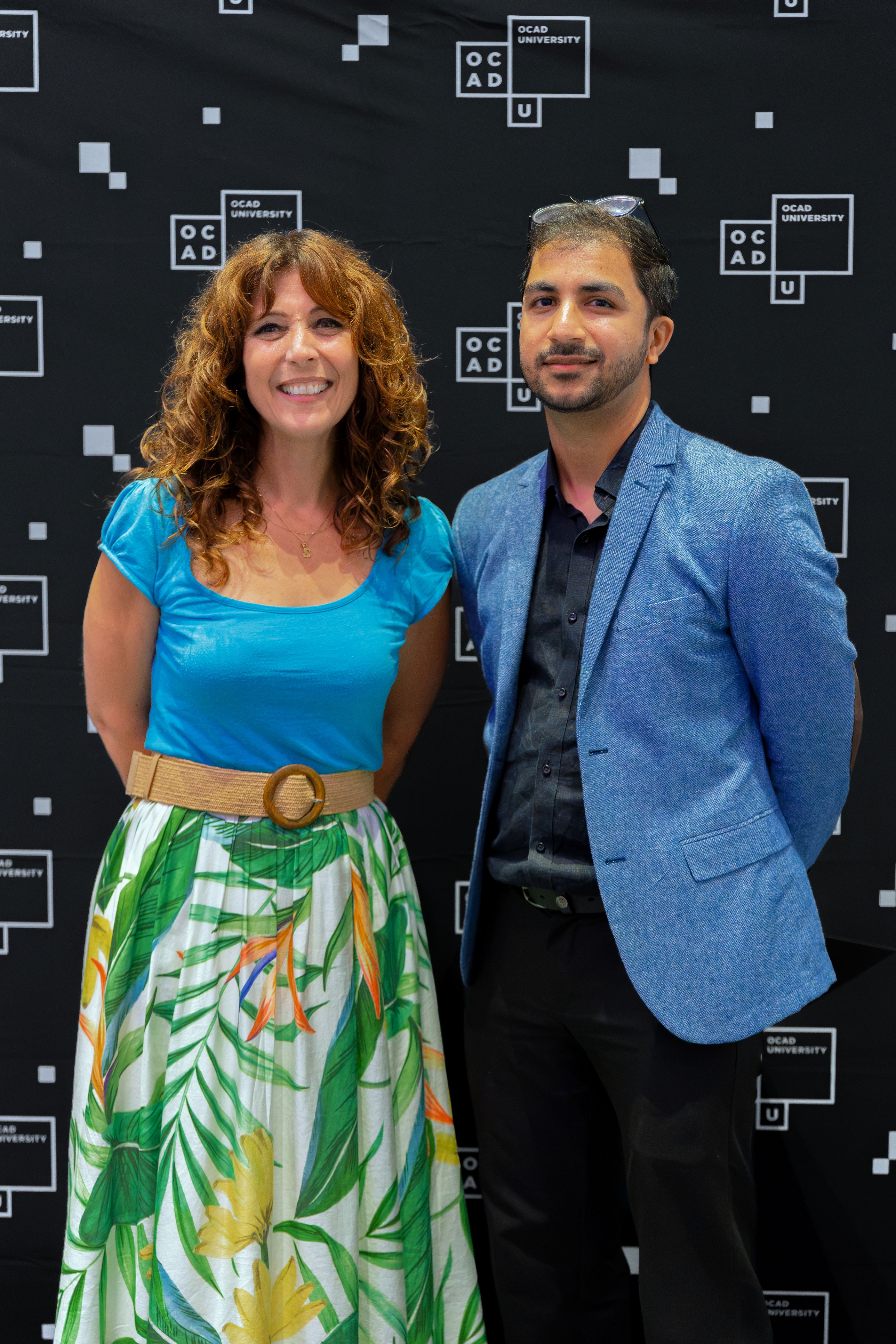 Left to right: Dr. Gabriele, wearing a blue top and green and white skirt with Parantap Bhatt, wearing a blue blazer, black shirt and black pants. 