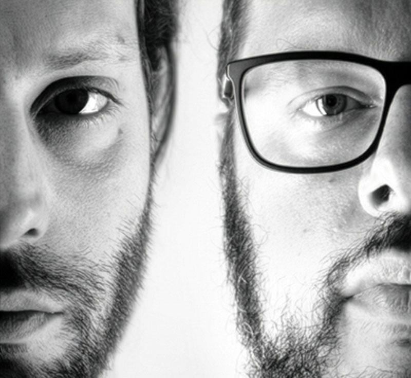 Black and white image of two people, showing half of their faces 