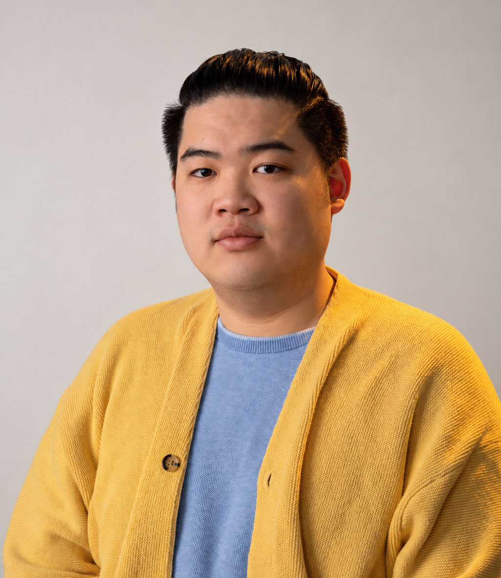 Image of young person wearing gold/yellow sweater with blue shirt
