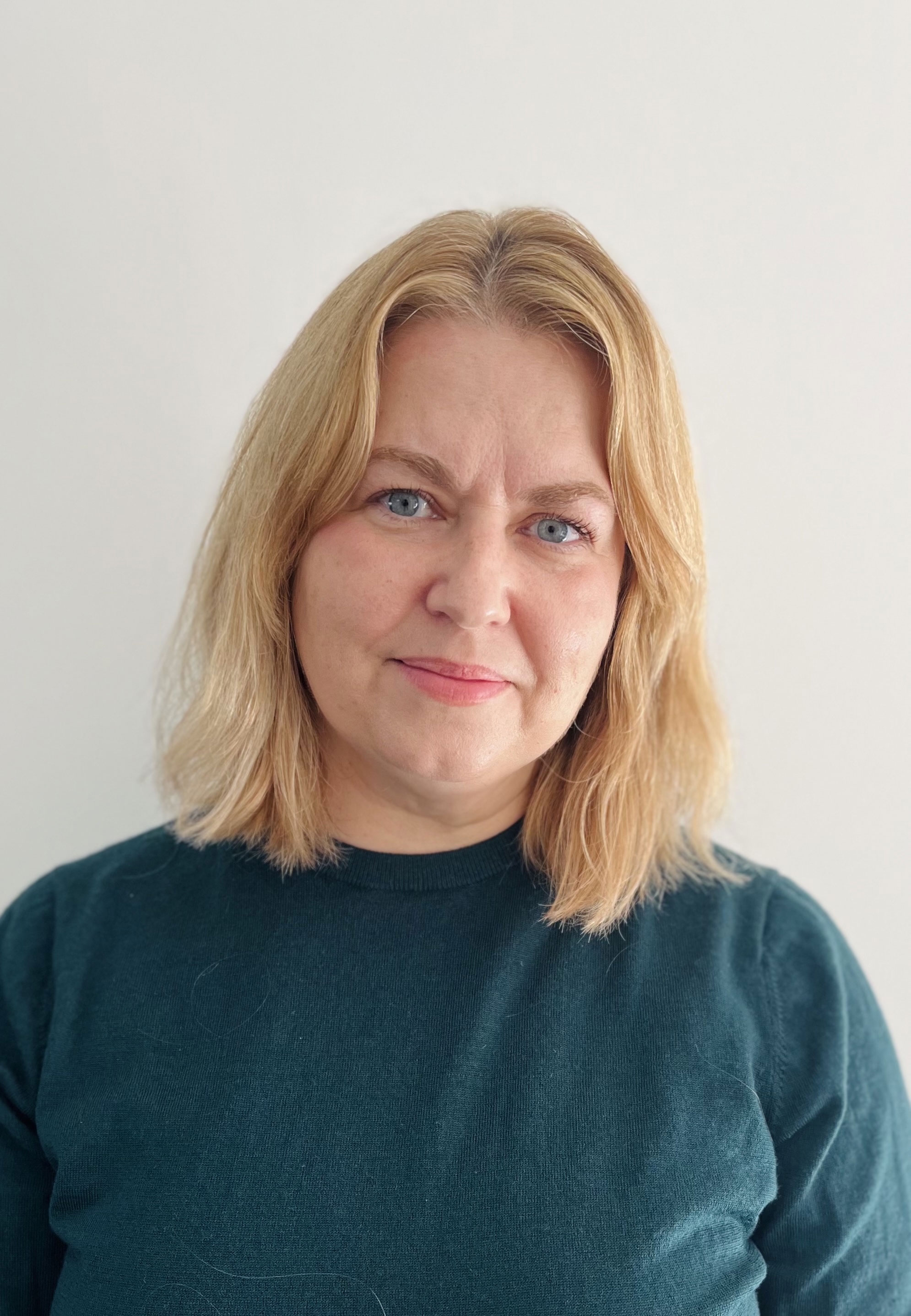 Woman with blond hair wearing green sweater
