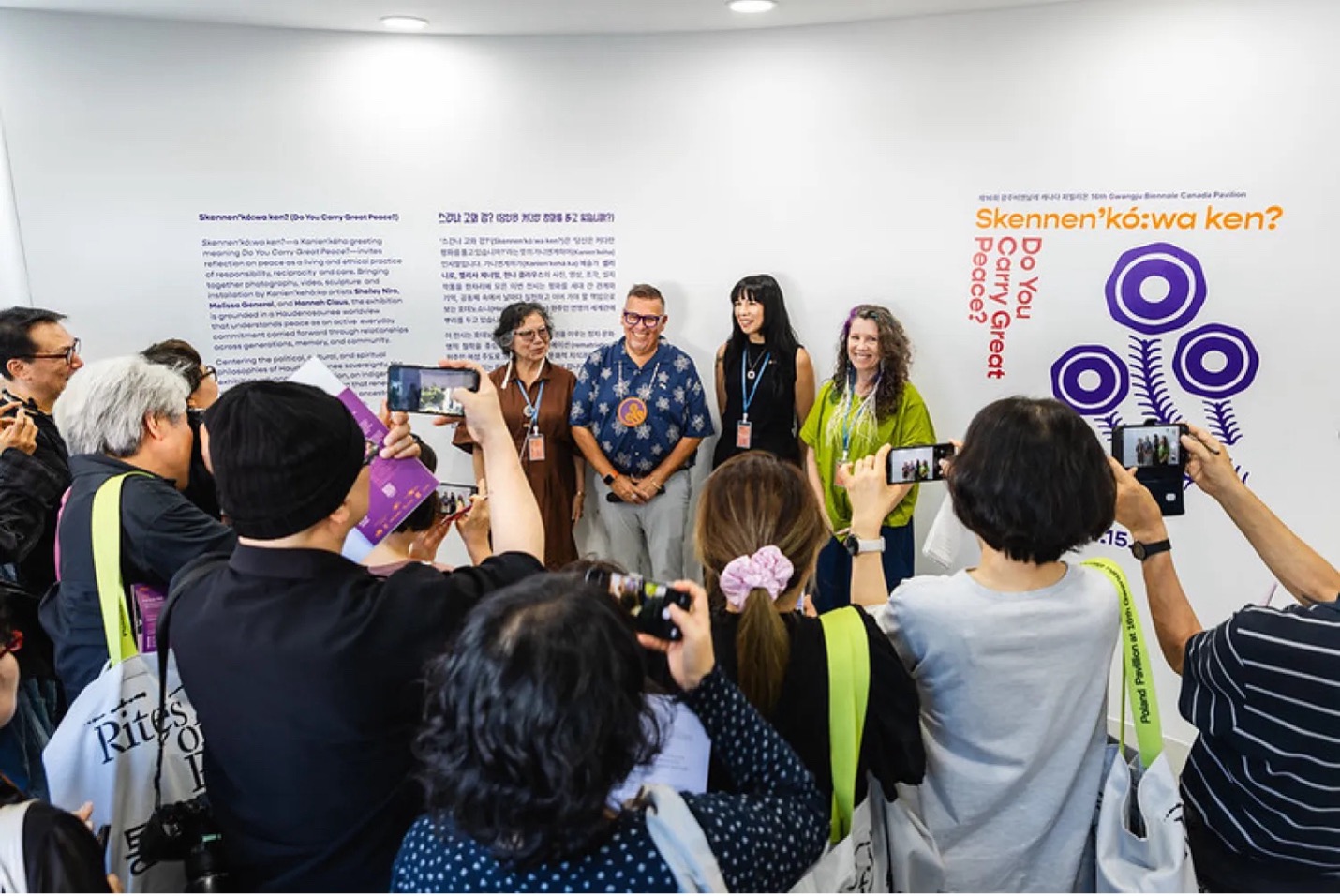 Four people standing at Gwangju Biennale with a crowd taking photos