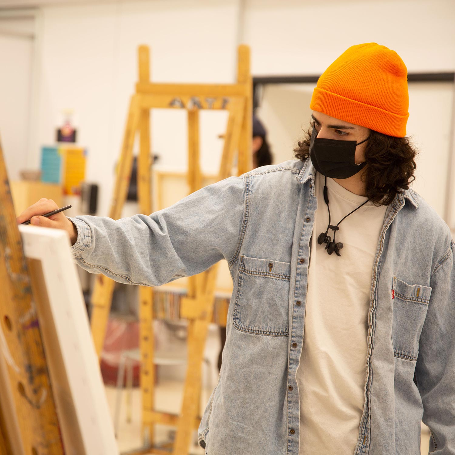 A photo of an art student painting on a canvas.