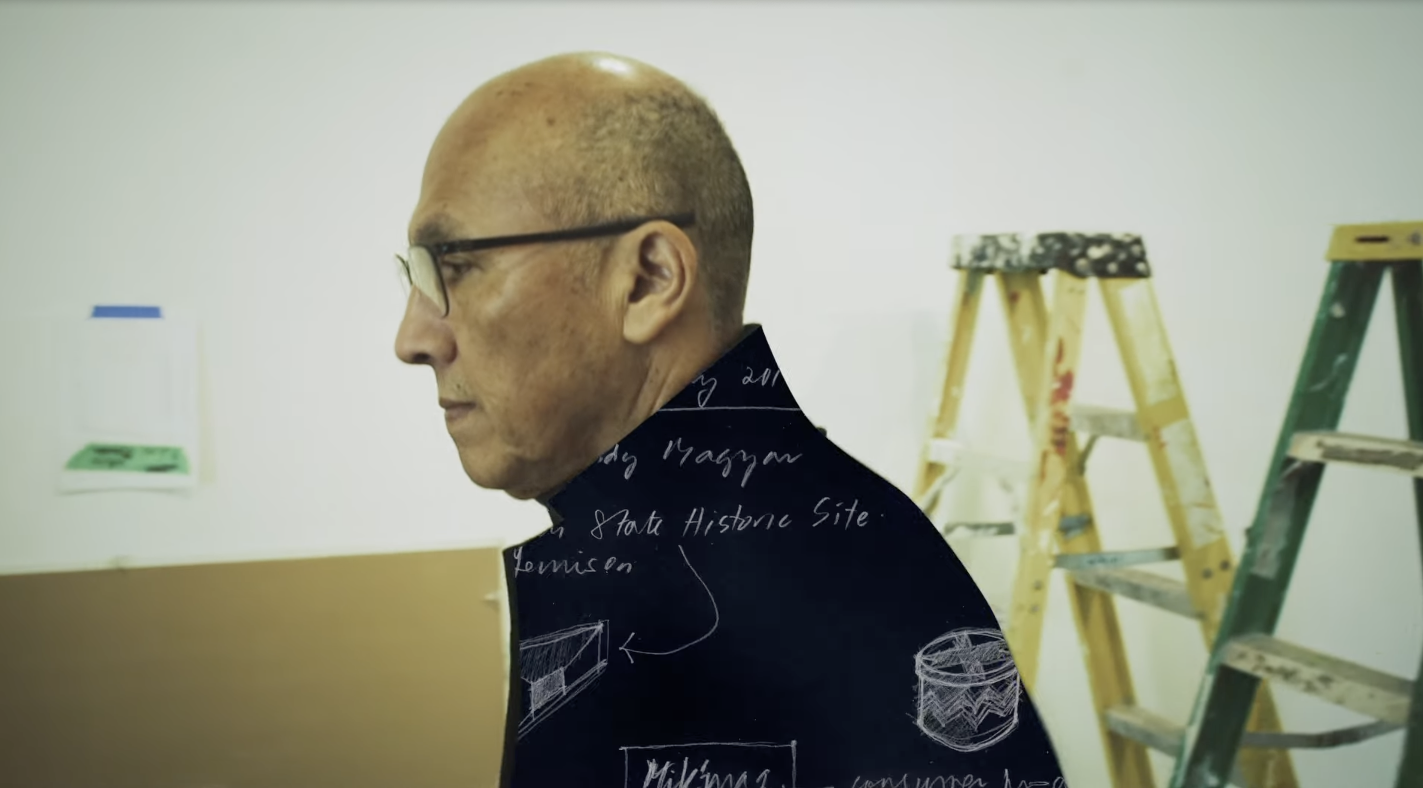 A photo of Dr. Gerald McMaster walking down a hallway.