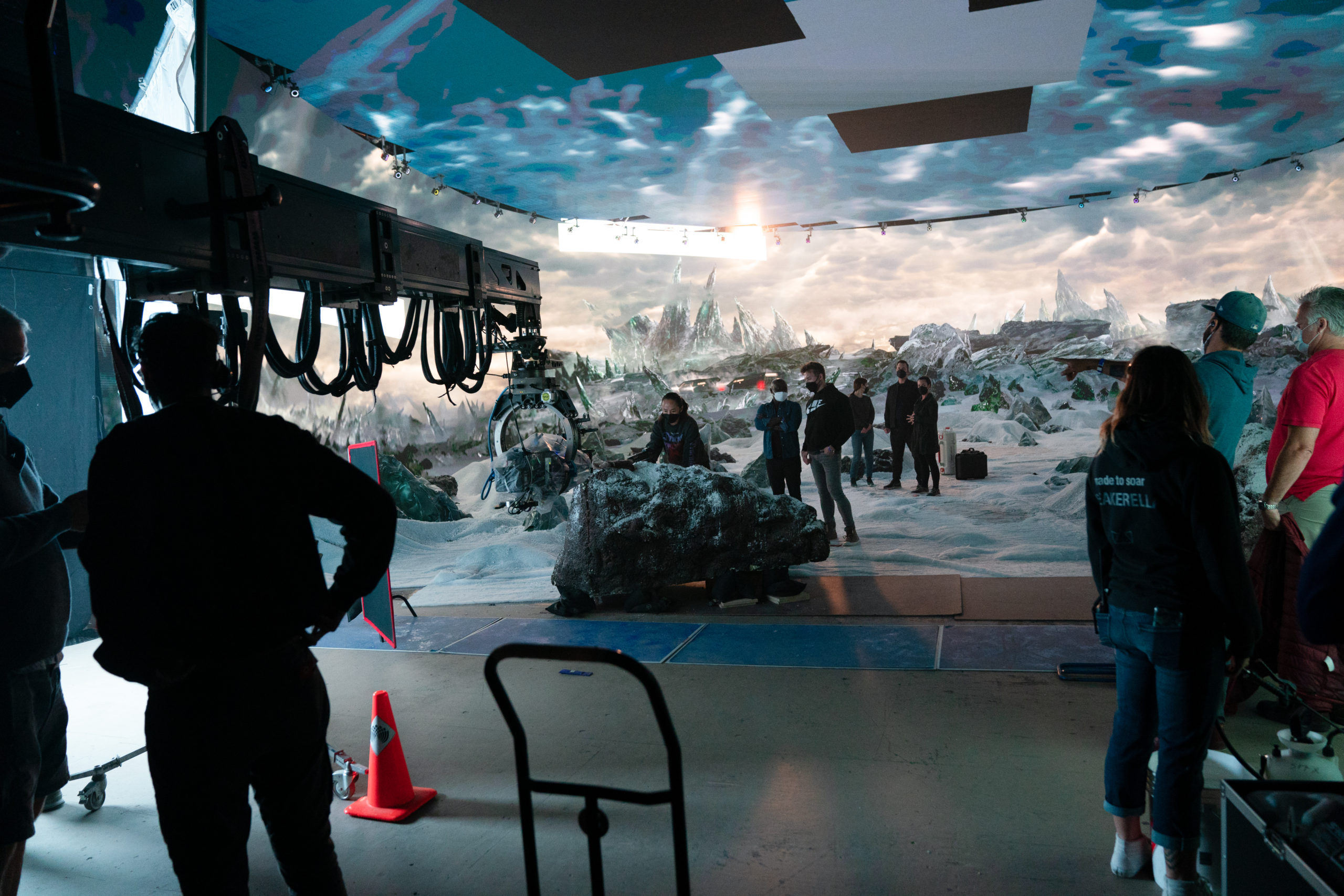 A film set with a backdrop of a futuristic winter landscape and a rock in the foreground.