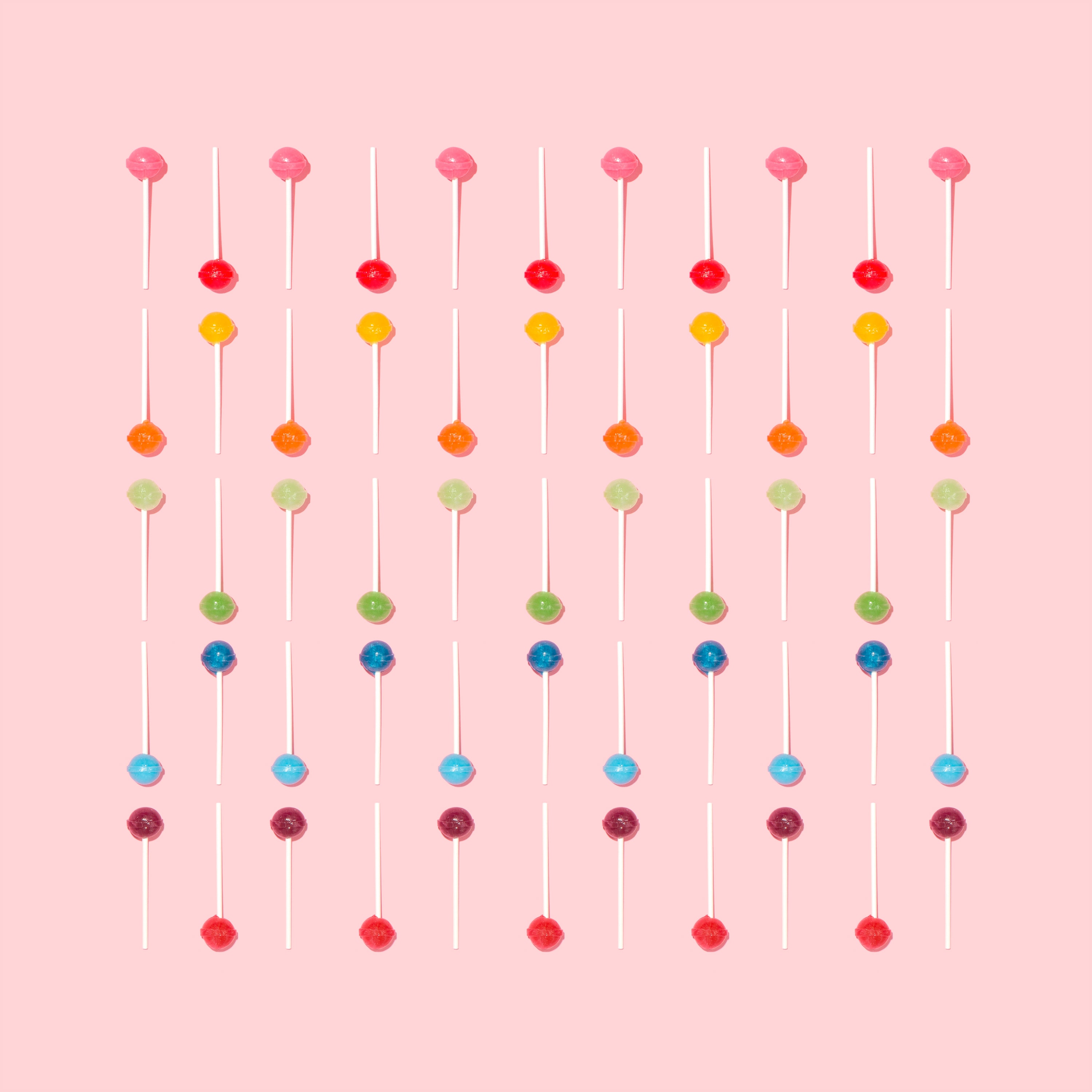 A photo of lollipops on a pink backdrop. 