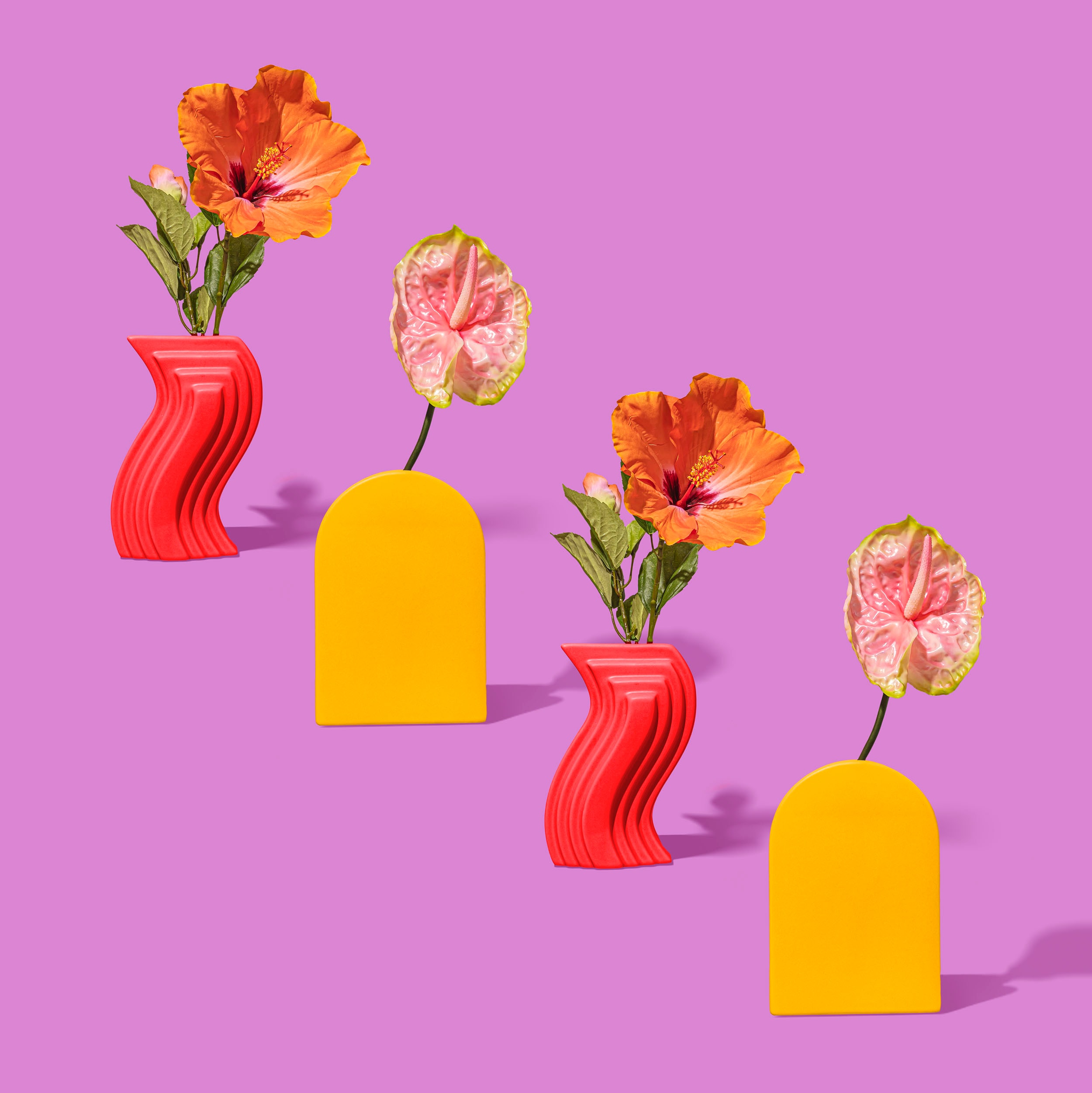 Tropical flowers in vases with a vibrant background.