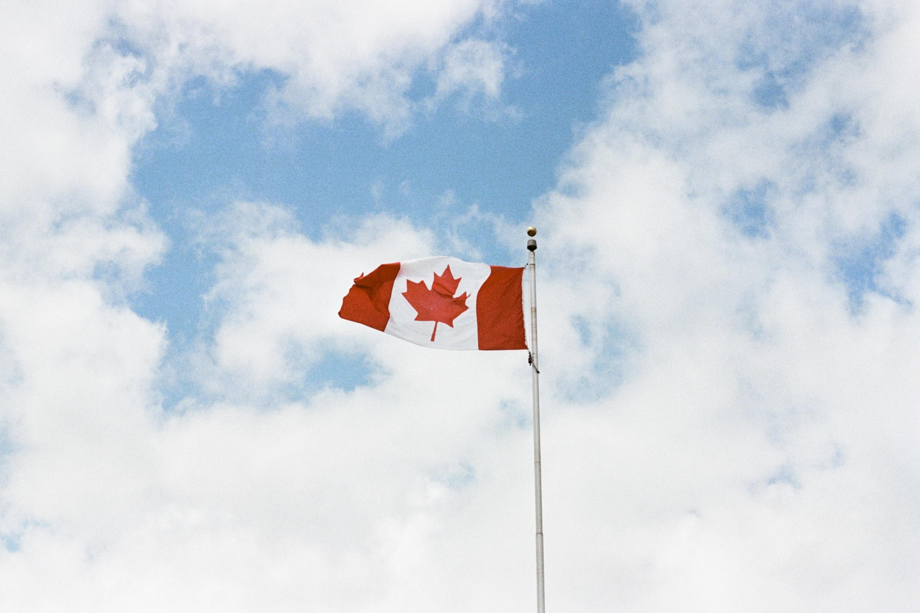 a Canadian flag on a sky background.