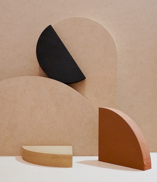 A still life photo of rounded shapes in shades of black, brown and beige. 