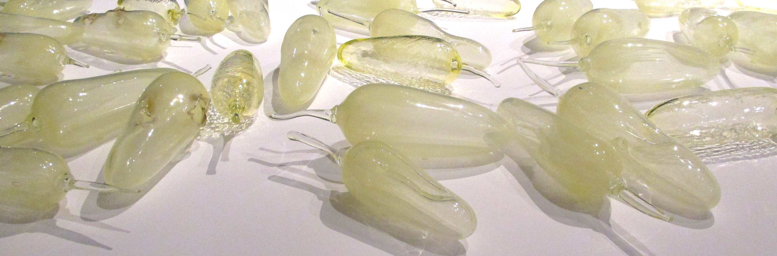 closely cropped photo of many translucent yellow glass bulbs on a white surface