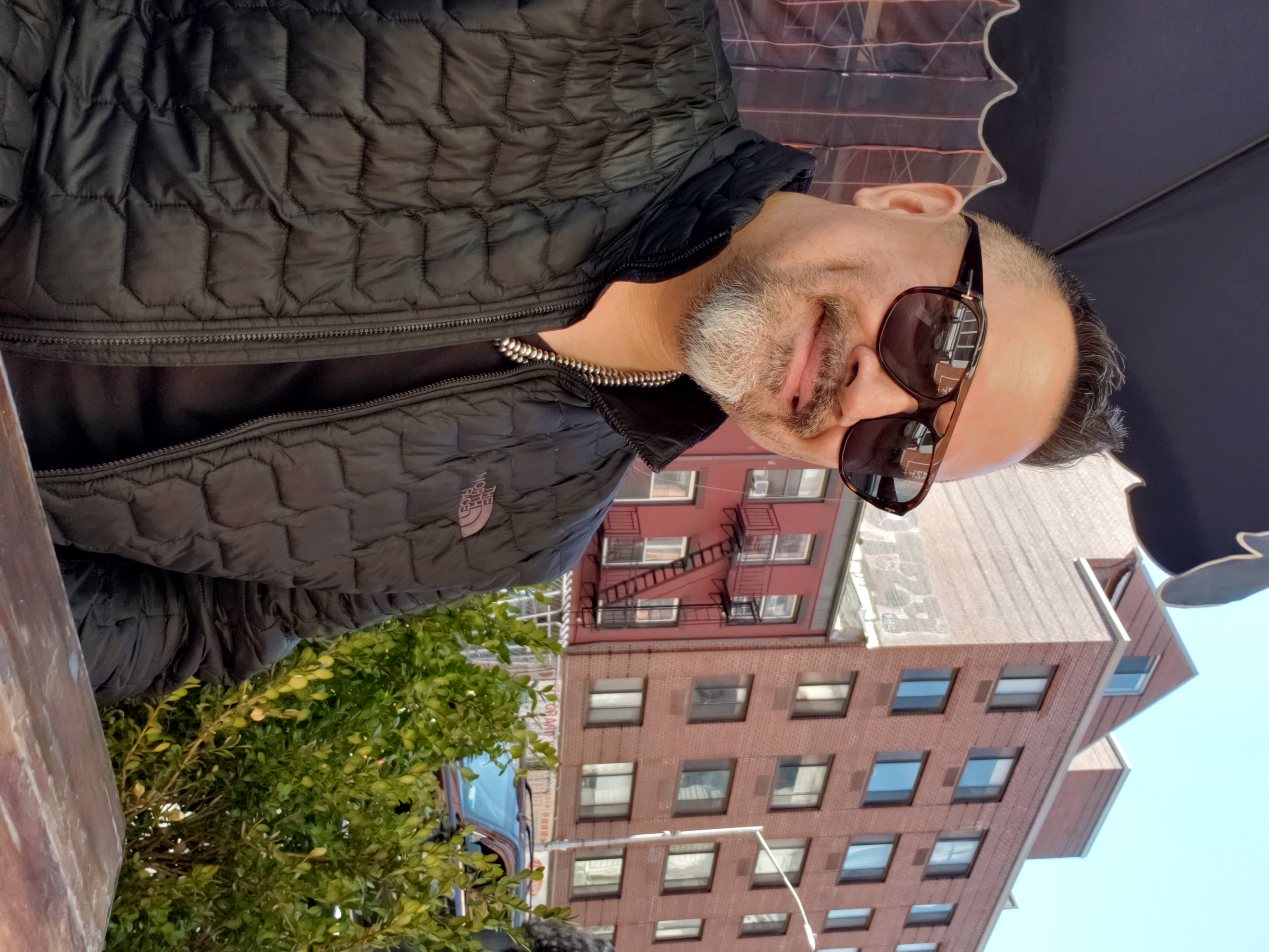 Head Shot of Grant Jonathan - a breaded man wearing sunglass while smiling