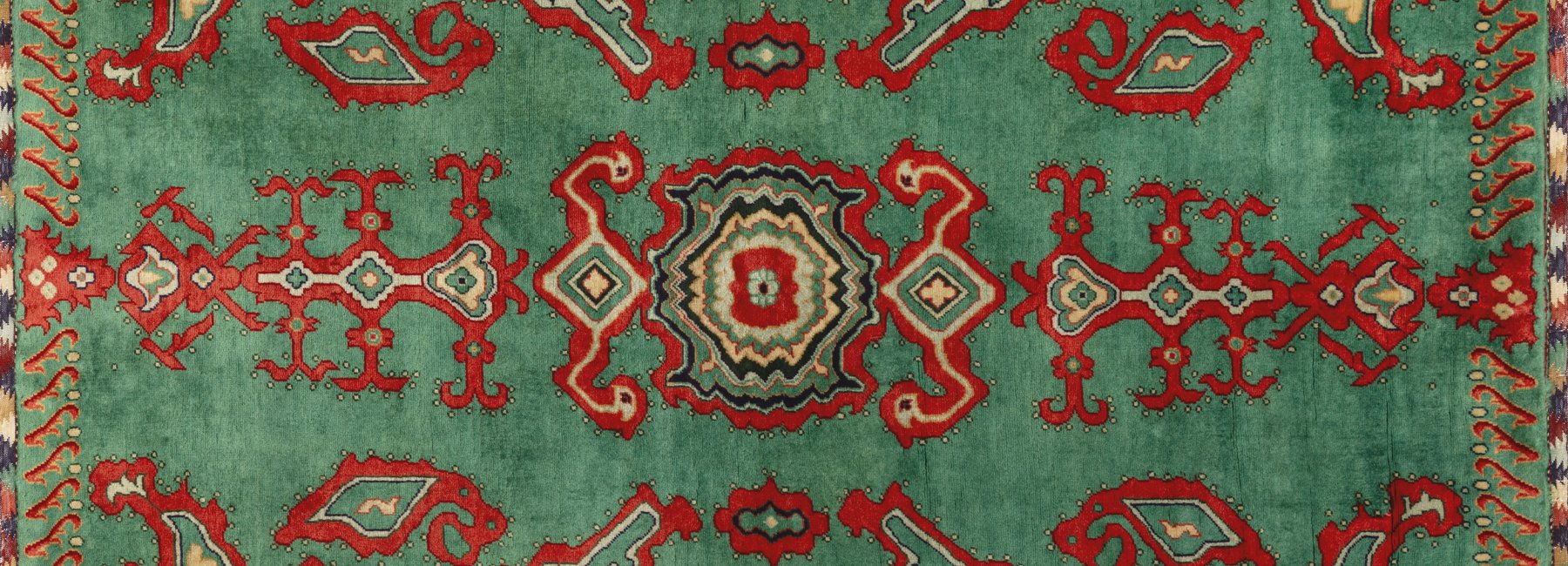 Close-up photo of the pattern on a multicoloured rug textile.