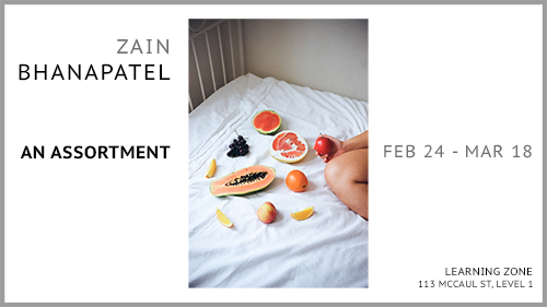 Photograph of an assortment of fruits and bare leg on bed with white sheets