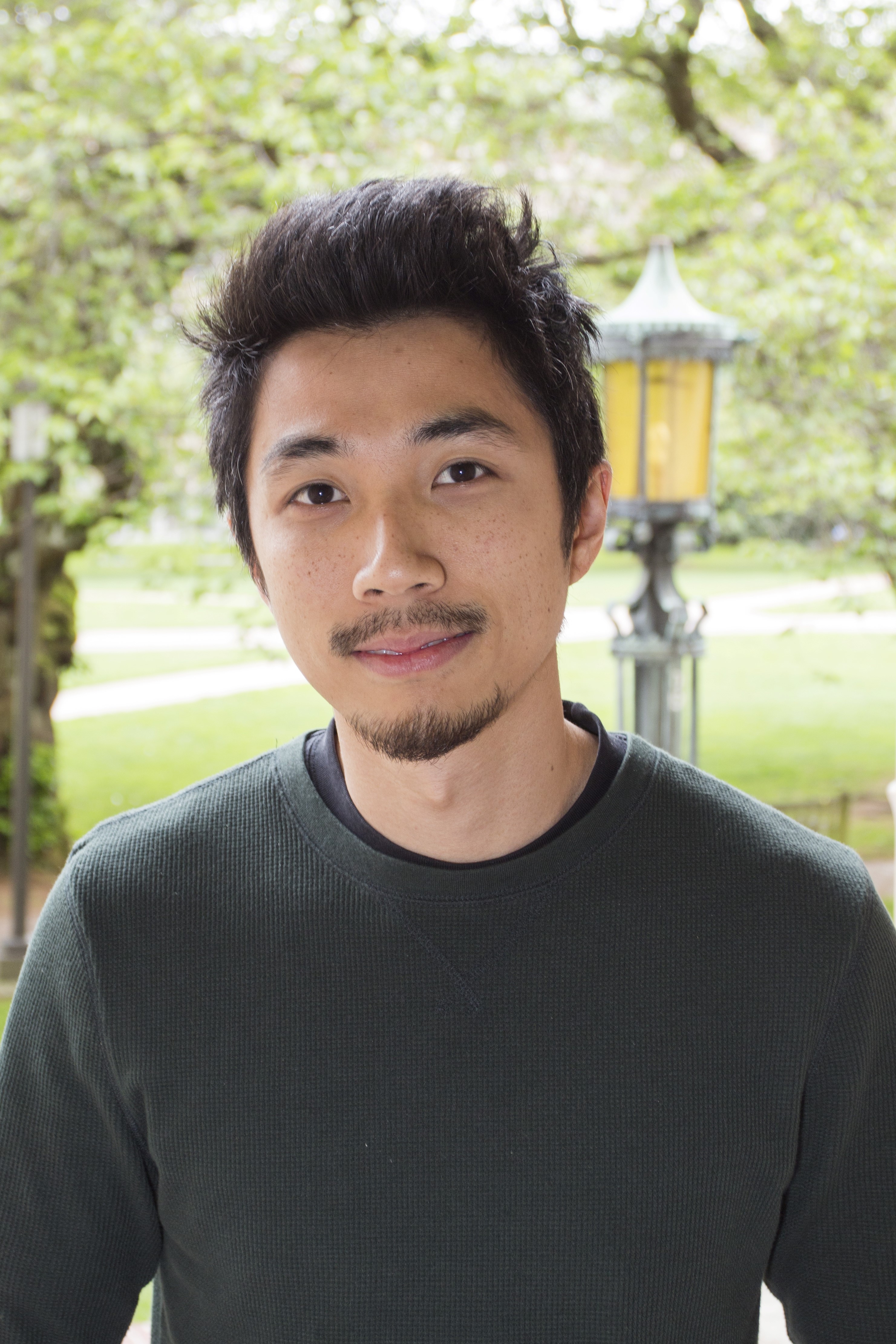 An image of a man with goatee and short black hair smiling at the camera