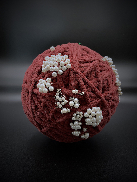A yarn ball is transformed into a globe in this artwork.