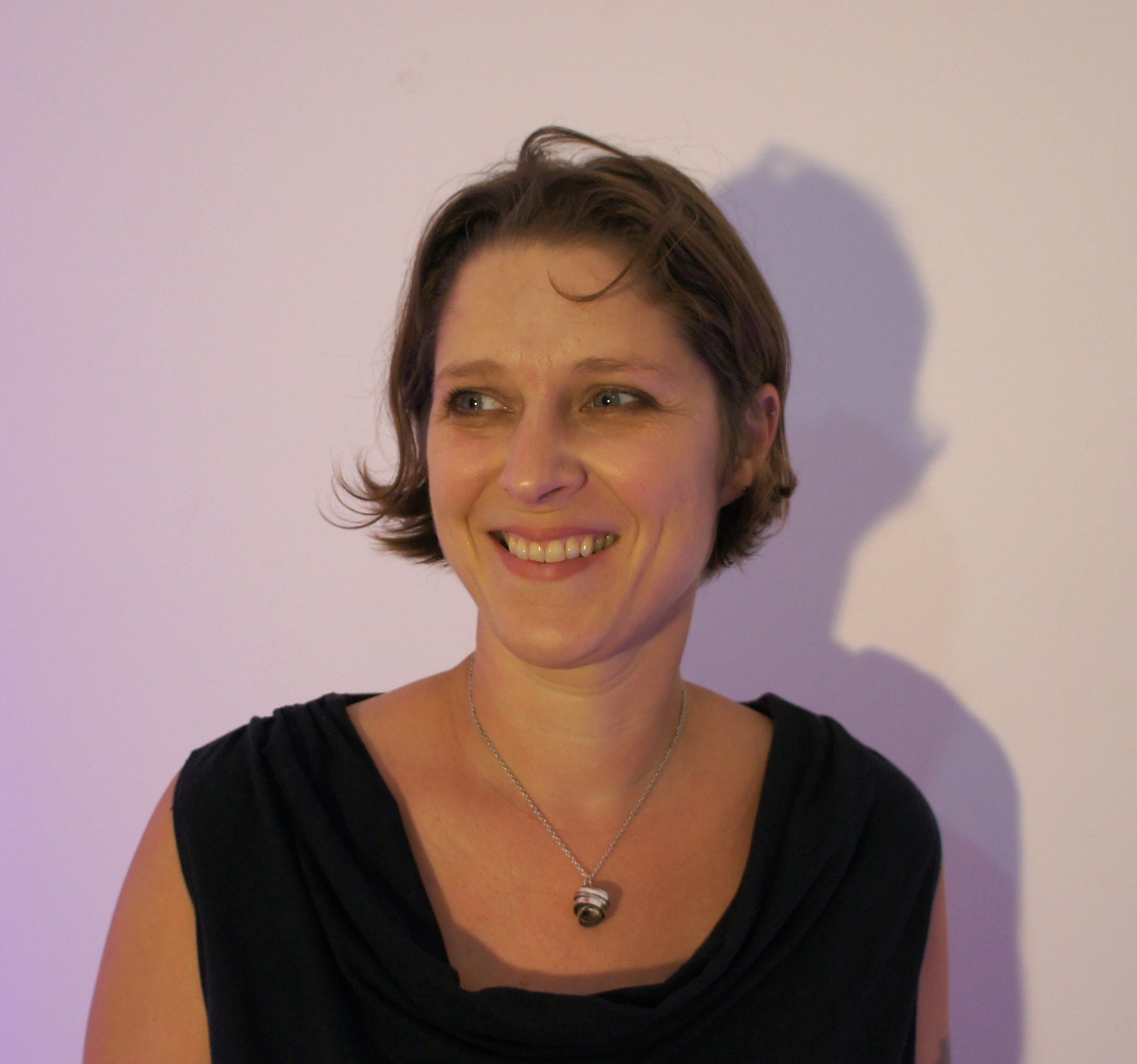 a woman smiling with short brown hair.