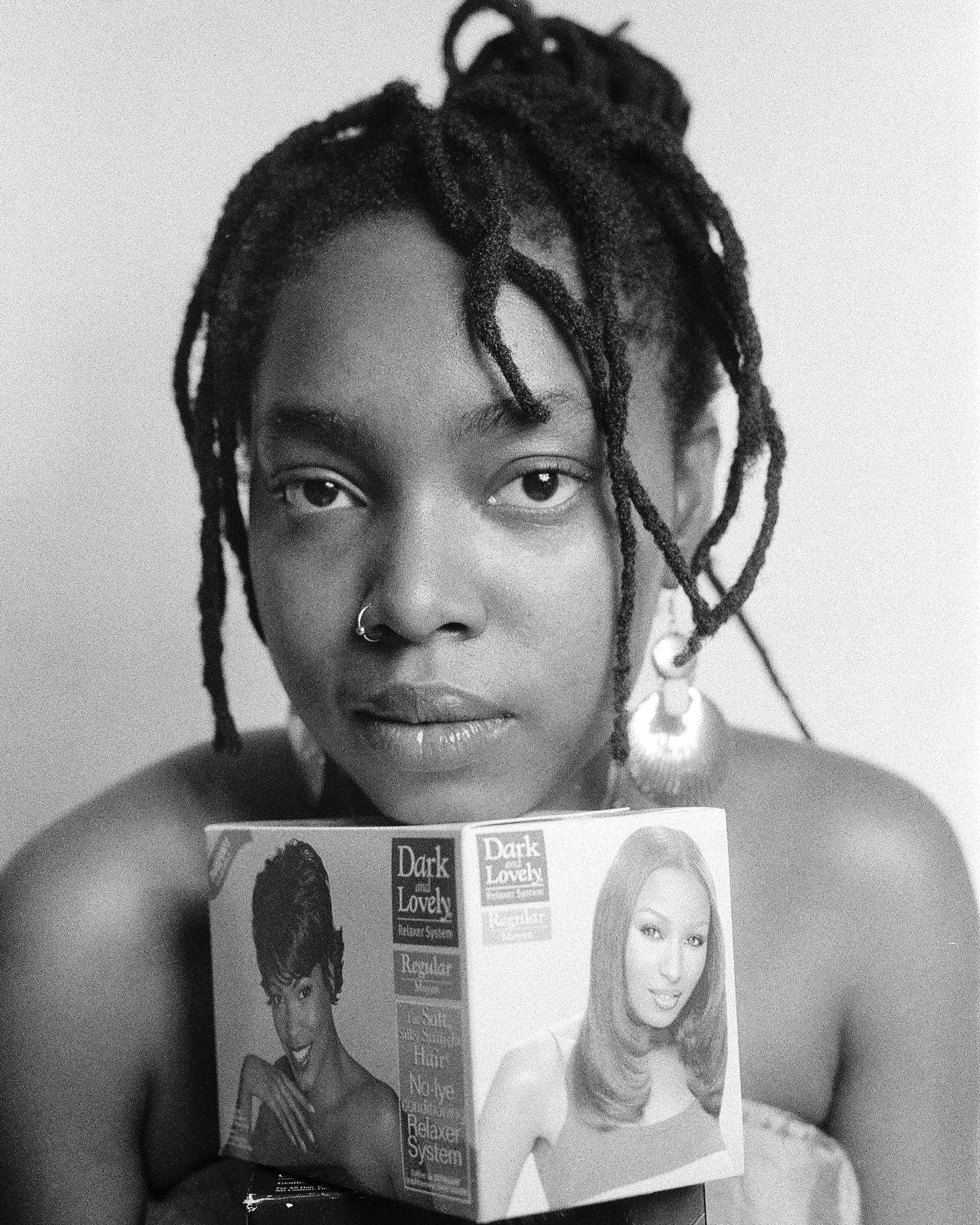 a woman with twisted braided hair holding a Dark and Lovely product.