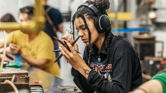 A student looking at and holding a small work of art.