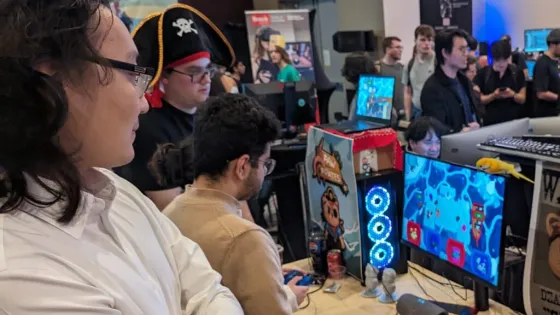 Attendees looking at a program on a computer monitor