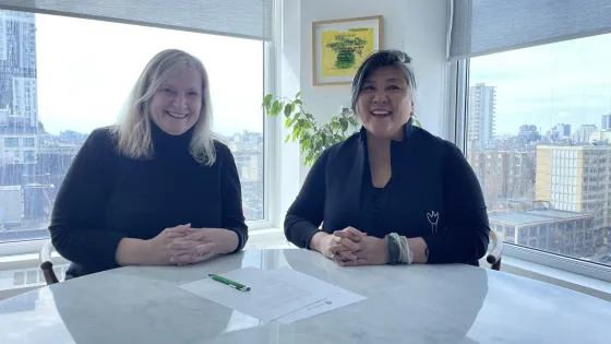 CSC Director Dr. Rebecca Malouin (left), with OCAD U President and Vice-Chancellor Ana Serrano (right) sitting at a table with documents in front of them. 