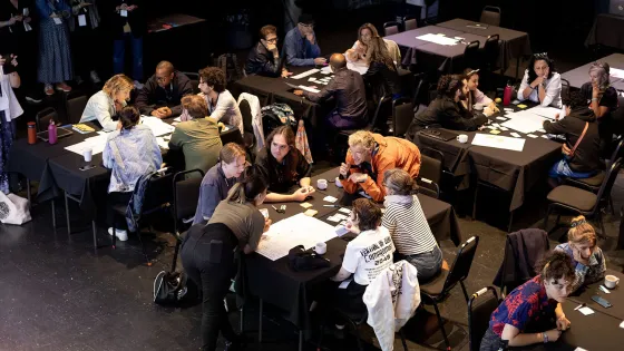 People gathered at different tables working at the Mutek Conference