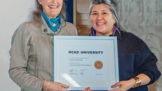 Ana Serrano and Sylvia Whitton stand holding a framed certificate.