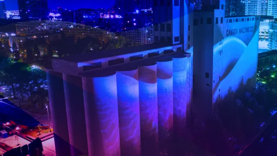 Photo of Canada Malting Siloes, a heritage building located at Toronto's Waterfront, overlayed with a blue, purple and pink gradient.