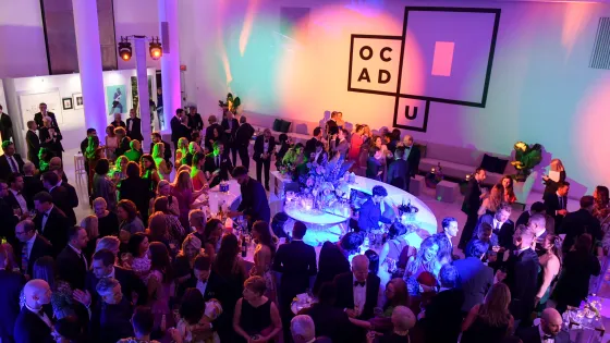 Guests mingle at the OCAD U Gala reception under colourful lighting.