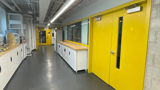 A view of a hallway at OCAD University. A set of yellow double doors is to the right of the hallway. 