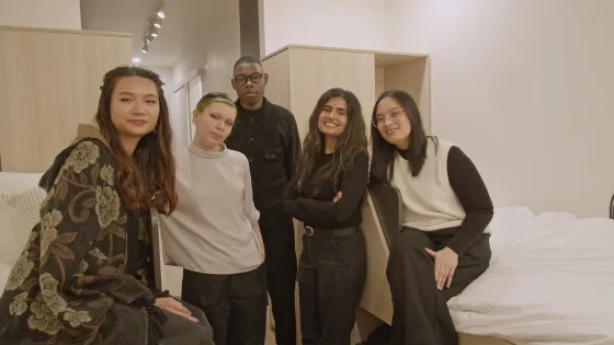 Design students standing in experimental housing unit