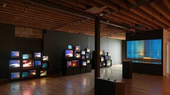 A number of TVs stacked on top of each other in an exhibition space.
