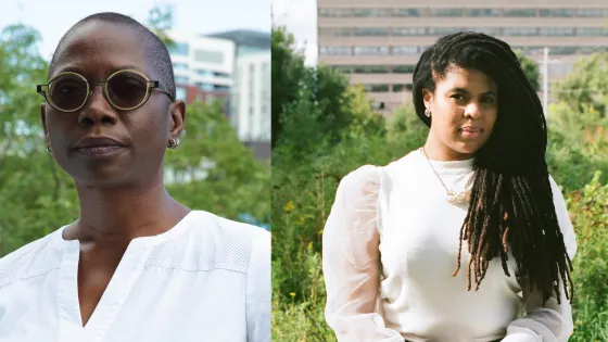Two women: on the left a woman with short hair, wearing sunglasses and white shirt. One the left a woman with long dreadlocks and cream colored sweater.