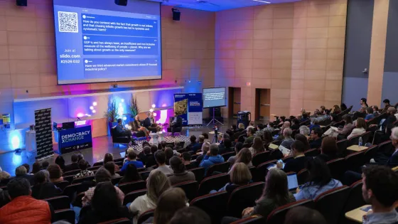Audience members sitting in an auditorium at a presentation. 