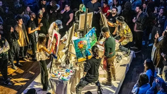 An illustration of a crowd of people watching others create paintings