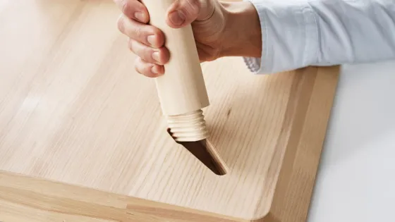 Person inserting a table leg into a flat packed table top