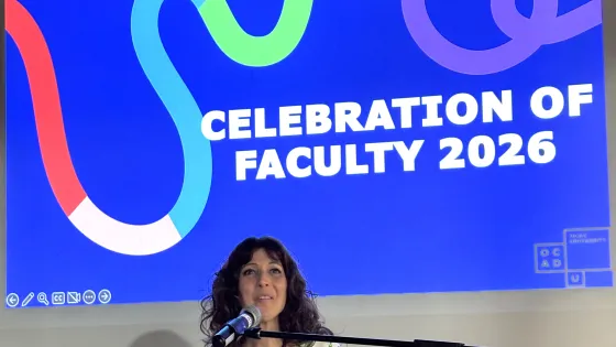 Provost Dr. Sandra Gabriele standing at podium with microphone, background slide of blue with colourful swirl saying, Celebration of Faculty 2026
