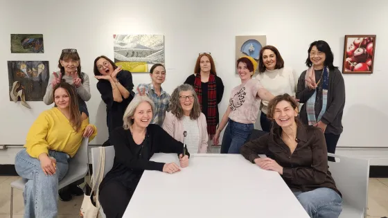 Students gathers in front of gallery wall