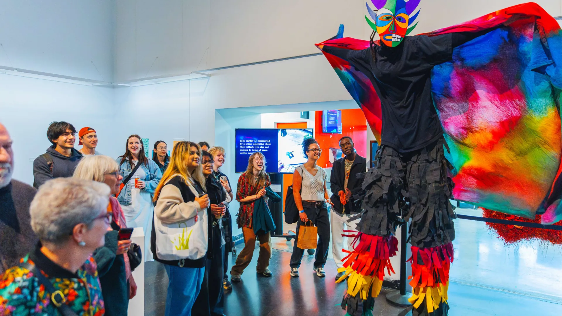 Person on stilts in colourful clothing performing in front of a small group