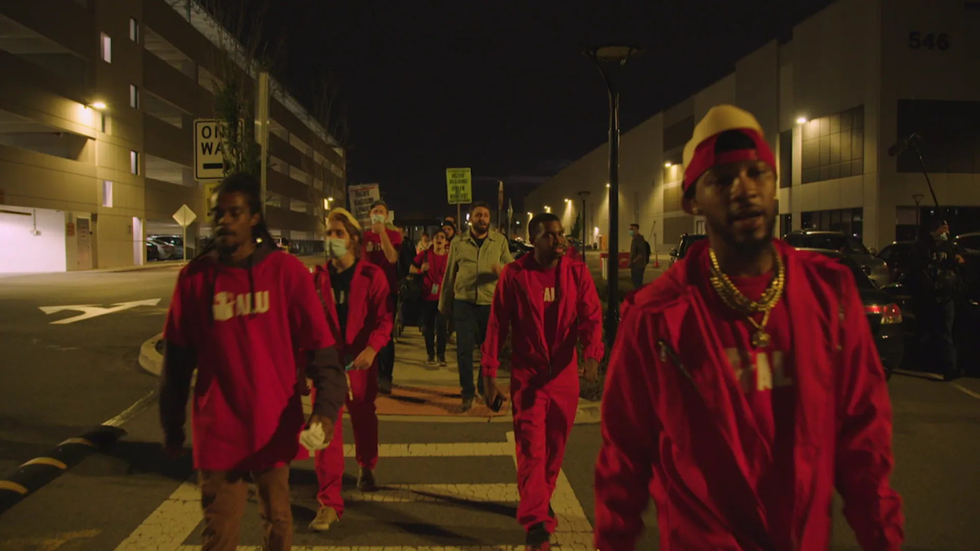 A group of black man wearing red outfit walked the evening urban set