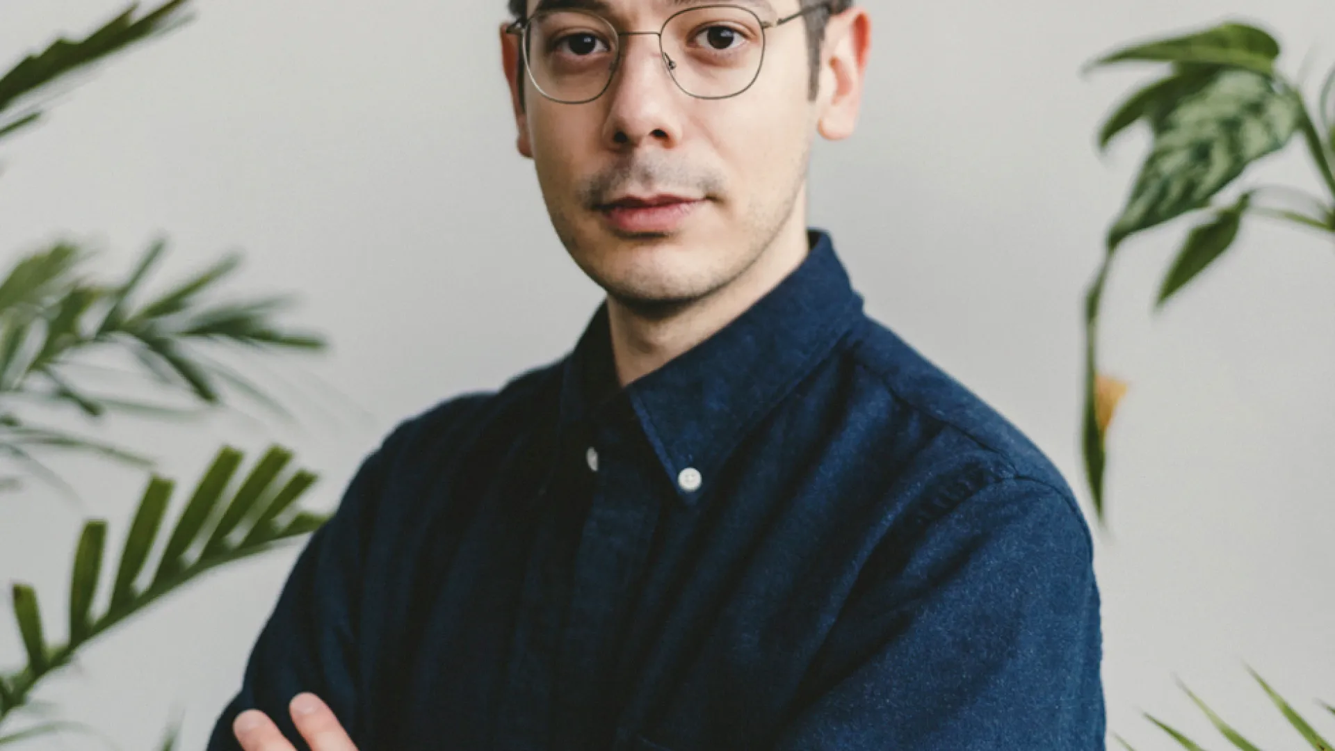 headshot of Erdem Tasdelen wearing a deep blue collar shirt with his arms crossed
