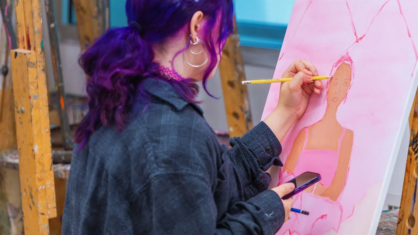 Student painting at an easel